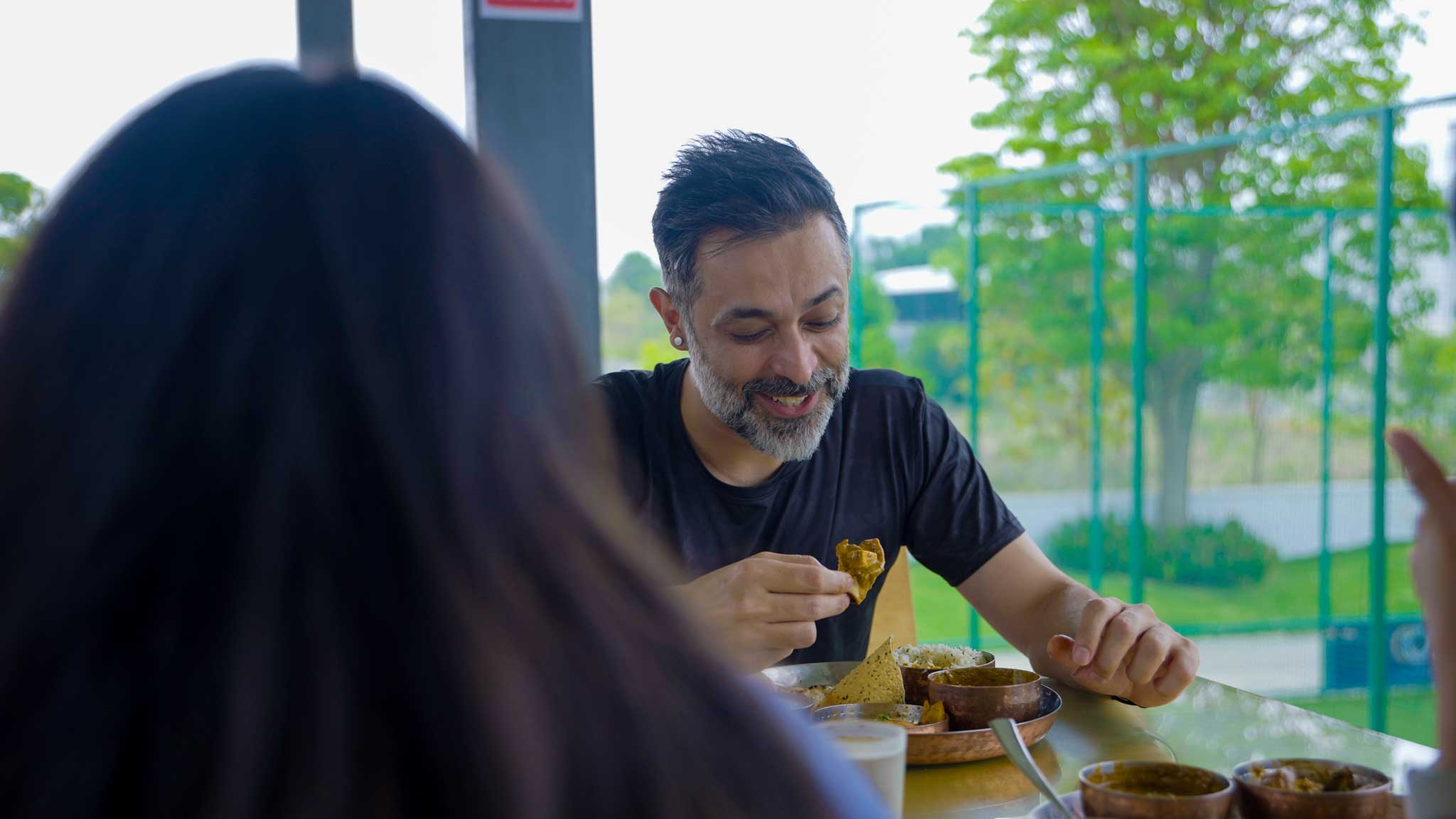 Man enjoying meal and smiling during Bengaluru’s Best Playcation food experience.